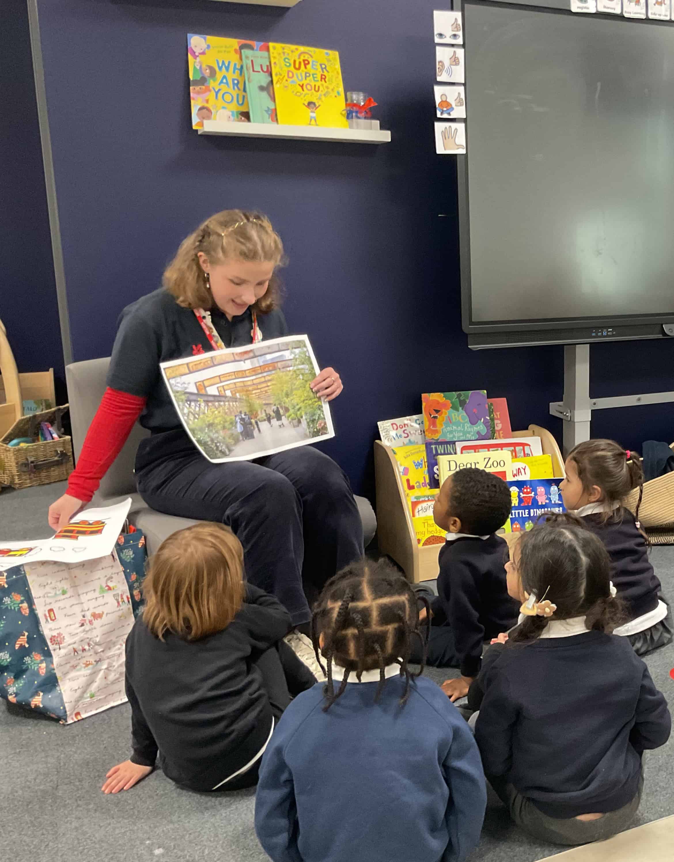 Image of visitor reading a book with pupils